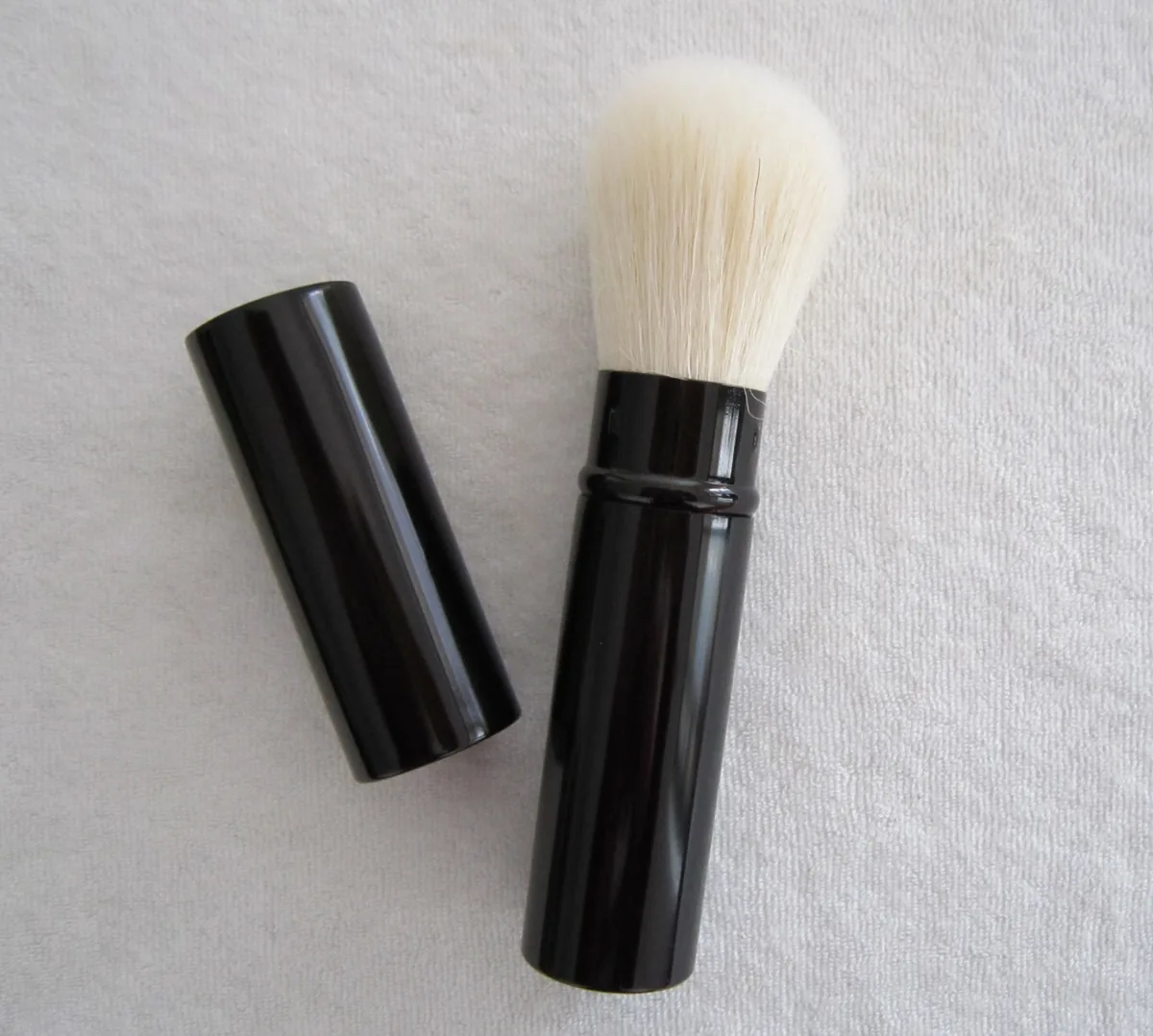Retractable powder brush